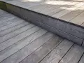 Szare, drewniane deski tarasowe tworzą schodek i podest. Zastanawiasz się, jakie drewno na taras wybrać?