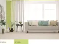 Jasny salon z kanapą i poduszkami w pastelowych kolorach. Ściany w odcieniu oliwkowym tworzą przytulną atmosferę.