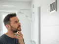 Mężczyzna zastanawia się nad działaniem wentylacji w łazience.