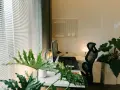 Nowoczesne domowe biuro z monitorem, laptopem i roślinami. Inspiracja, jak urządzić domowe biuro, by było funkcjonalne i estetyczne.