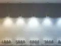 Rząd lamp oświetla ścianę, ukazując pełne spektrum barwy światła od ciepłej żółci do zimnego błękitu, z oznaczeniami temperatur barwowych.