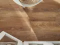 Drewnopodobne panele laminowane czy winylowe tworzą ciepłą podłogę. Białe meble i pleciony kosz dodają stylu.