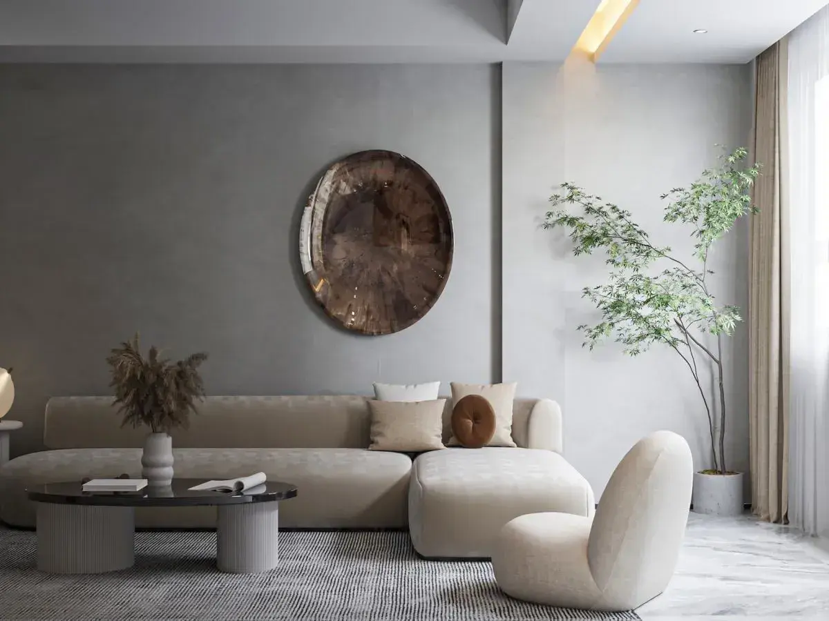 Nowoczesny salon w stylu minimalizm: beżowa sofa, okrągły stolik, dekoracyjna taca i drzewko w donicy tworzą spokojną przestrzeń.