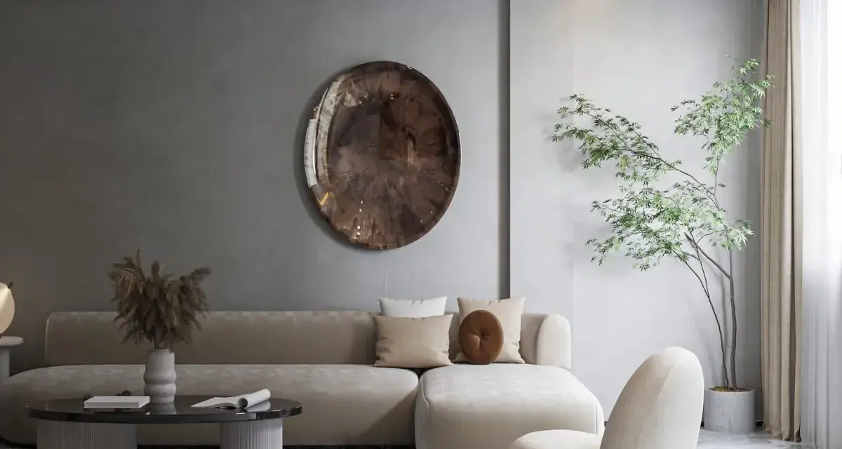 Nowoczesny salon w stylu minimalizm: beżowa sofa, okrągły stolik, dekoracyjna taca i drzewko w donicy tworzą spokojną przestrzeń.