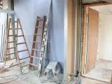 Remont mieszkania 60m2 w toku. Drabiny, poziomica i materiały budowlane wskazują na prace.