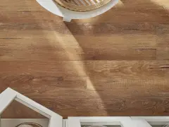 Drewnopodobne panele laminowane czy winylowe tworzą ciepłą podłogę. Białe meble i pleciony kosz dodają stylu.