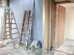 Remont mieszkania 60m2 w toku. Drabiny, poziomica i materiały budowlane wskazują na prace.