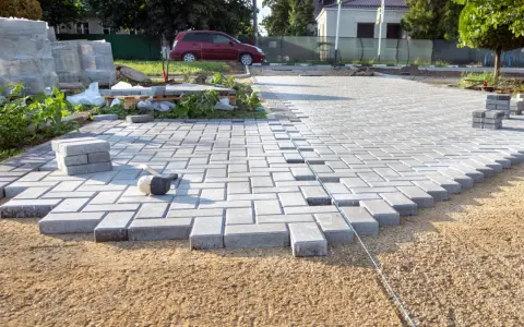 Układanie kostki brukowej na podjeździe. To świetny pomysł na tani podjazd, który można wykonać samodzielnie.