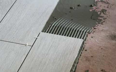 Układanie płytek 60x60 cennik. Nowe płytki na kleju, widoczne krzyżyki dystansowe.