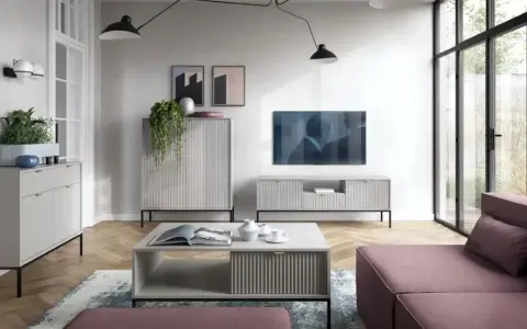 Nowoczesny salon z dużą **ścianą TV**, minimalistycznymi meblami i wygodną, różową sofą.
