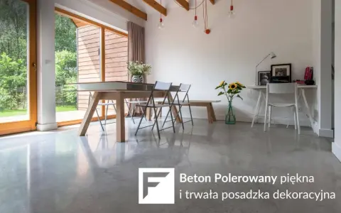 Jasna, polerowana podłoga betonowa w nowoczesnym salonie z drewnianymi elementami i dużymi oknami.