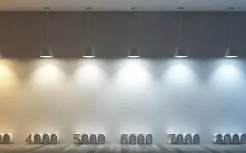 Rząd lamp oświetla ścianę, ukazując pełne spektrum barwy światła od ciepłej żółci do zimnego błękitu, z oznaczeniami temperatur barwowych.