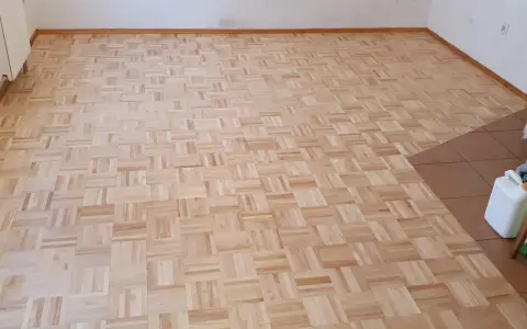 Odnowiony parkiet w jodełkę. Zastanawiasz się, ile kosztuje cyklinowanie parkietu? Ten piękny, drewniany wzór czeka na renowację.