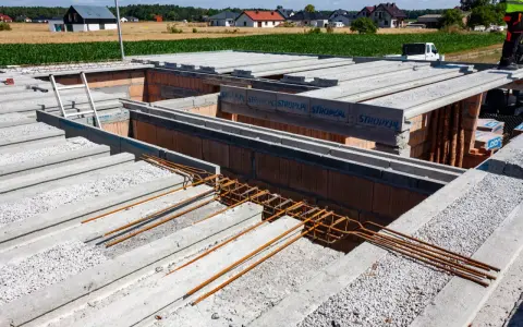 Budowa stropu Teriva z pustaków i belek betonowych, widoczne zbrojenie.