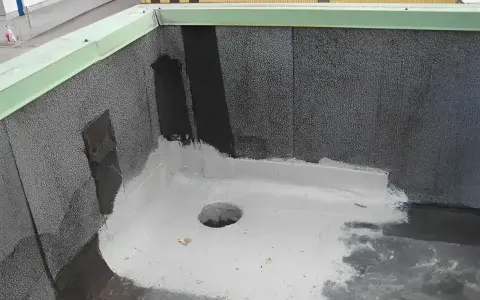 Fragment dachu z widocznym odpływem i nową warstwą hydroizolacji z **elastomeru**.