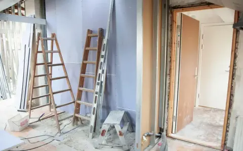 Remont mieszkania 60m2 w toku. Drabiny, poziomica i materiały budowlane wskazują na prace.