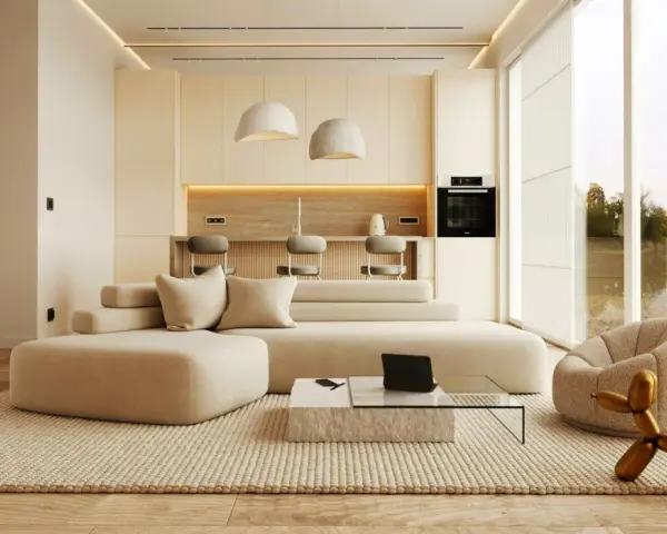 Nowoczesny salon z aneksem kuchennym. Duża, beżowa sofa i dywan tworzą przytulną przestrzeń, idealną dla miłośników minimalizmu w domu.