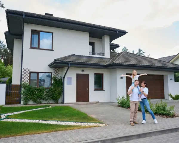 Szczęśliwa rodzina przed nowoczesnym domem. Szacowany koszt budowy domu 220m2.