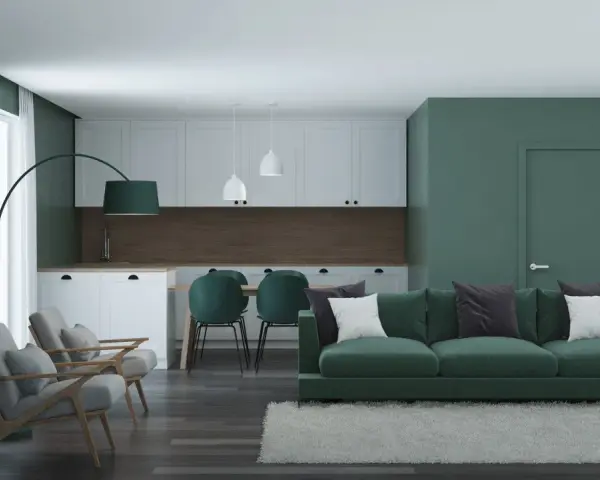 Nowoczesny salon z kuchnią w odcieniach zieleni. Seledynowy kolor ścian i mebli tworzy spokojną atmosferę.