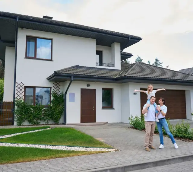 Szczęśliwa rodzina przed nowoczesnym domem. Szacowany koszt budowy domu 220m2.