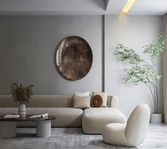Nowoczesny salon w stylu minimalizm: beżowa sofa, okrągły stolik, dekoracyjna taca i drzewko w donicy tworzą spokojną przestrzeń.