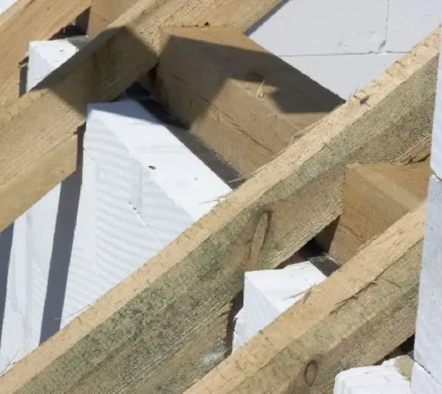 Drewniana konstrukcja dachu, widoczna murłata, białe bloczki betonu komórkowego.