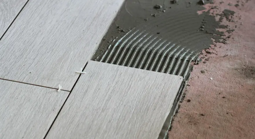 Układanie płytek 60x60 cennik. Nowe płytki na kleju, widoczne krzyżyki dystansowe.