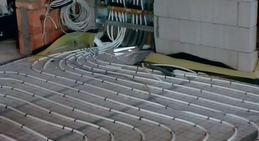 Instalacja podłogówki w trakcie prac. Sprawdź, jaka jest podłogówka cena za m2 robocizny.