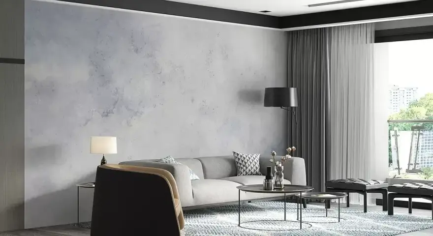 Nowoczesny salon z sofą, stolikami i dywanem. Ściana za sofą ma subtelny **efekt betonu**, nadając wnętrzu industrialny charakter.