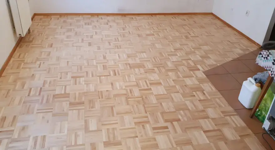 Odnowiony parkiet w jodełkę. Zastanawiasz się, ile kosztuje cyklinowanie parkietu? Ten piękny, drewniany wzór czeka na renowację.