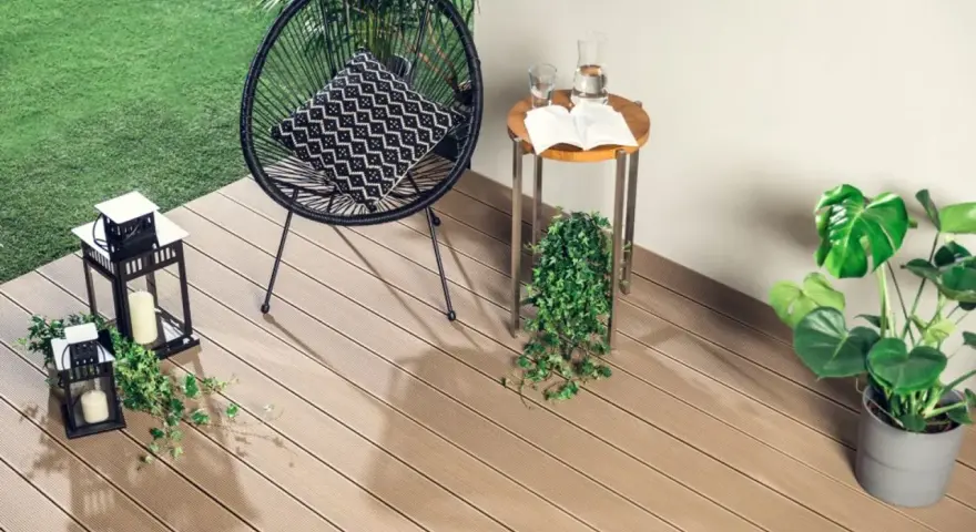 Nowoczesne deski kompozytowe to świetny pomysł, czym wyłożyć balkon. Wygodne krzesło, stolik i latarenki tworzą przytulną atmosferę.