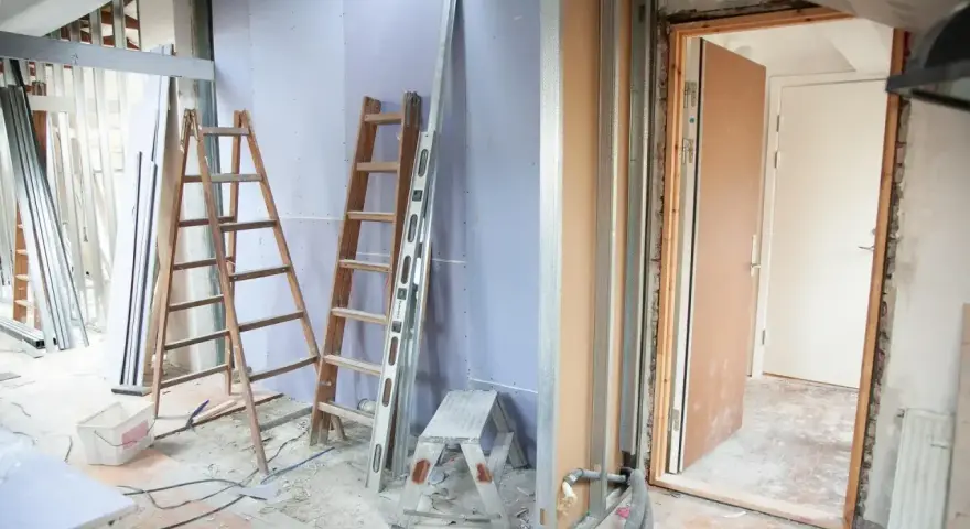 Remont mieszkania 60m2 w toku. Drabiny, poziomica i materiały budowlane wskazują na prace.