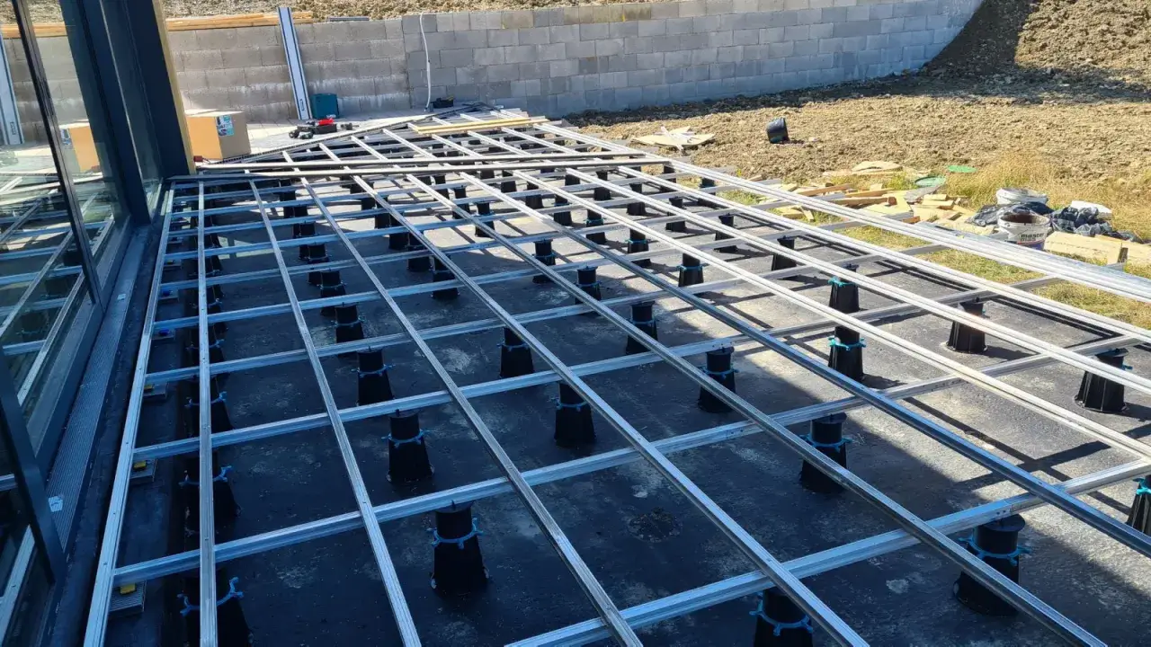 Konstrukcja tarasu wentylowanego w trakcie budowy. Widoczny system aluminiowych legarów na regulowanych wspornikach. Sprawdź atrakcyjną taras wentylowany cena za m2.