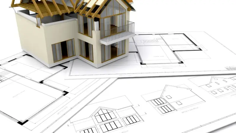 Model domu na planach architektonicznych. Zastanawiasz się, ile trwa budowa domu? To zależy od wielu czynników, ale zaczyna się od projektu.